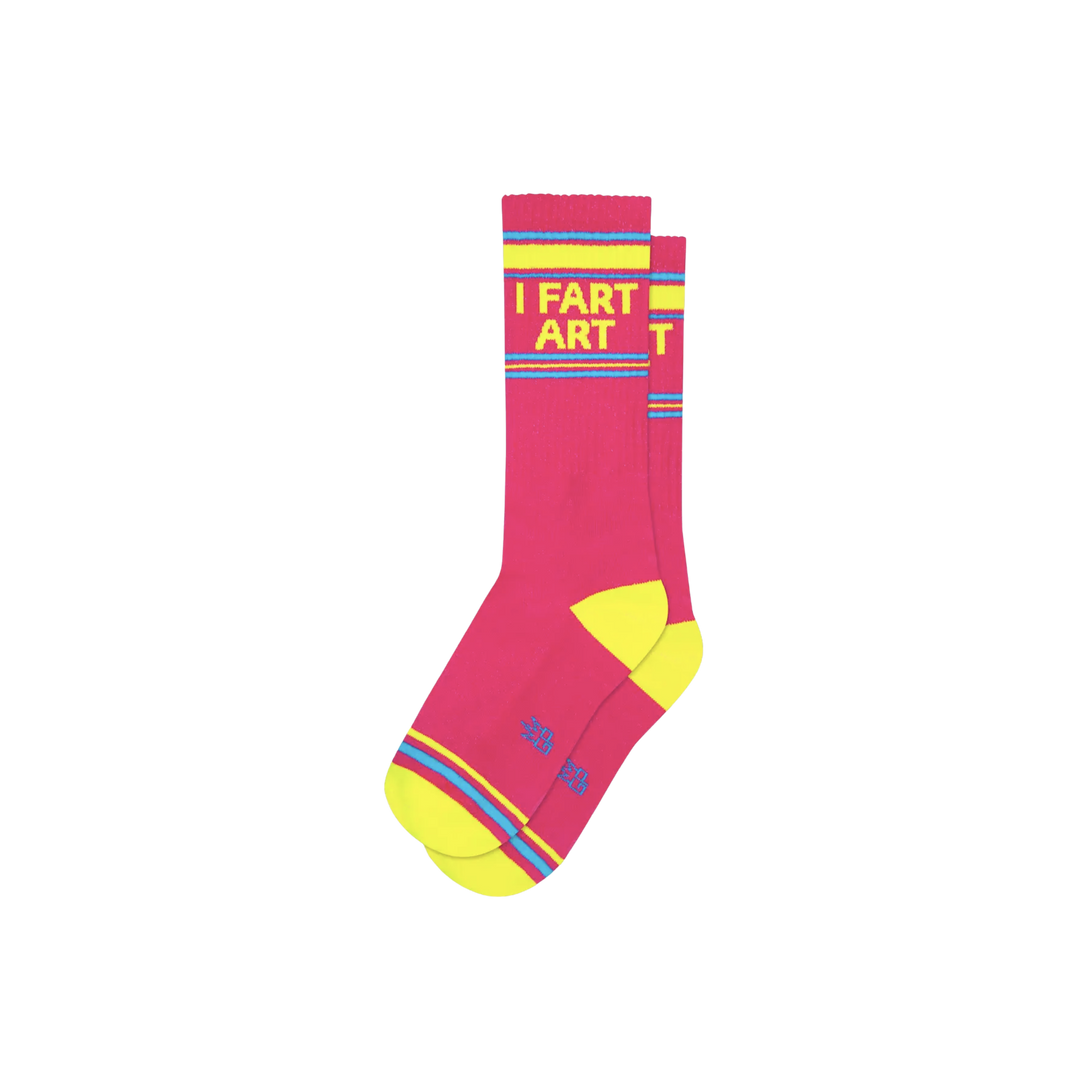 Pink socks with blue and yellow stripes and text "I Fart Art". Art can take on many shapes. You can listen to it 🎶, witness it 🎭, taste it 👨🍳, feel it 🤡, or smell it 👃. With I Fart Art Gym Socks, you get it all! 💨 Capture the essence of your individuality and give it a name 🖼 Crafted in the United States, using 62% Cotton, 32% Nylon, and 3% Spandex.