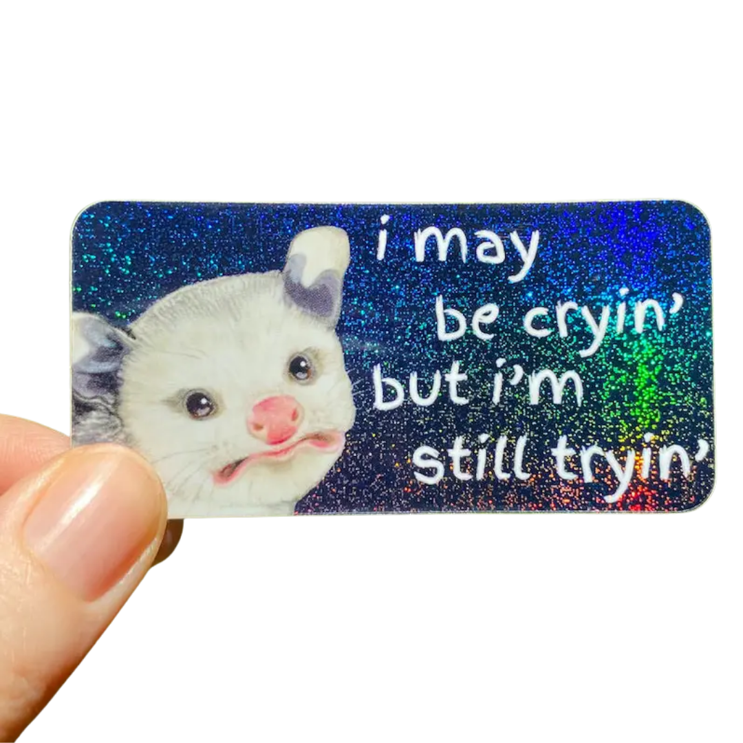 Baby Opossum “I May Be Cryin’ But I’M Still Tryin’” Sparkly Rainbow Sticker