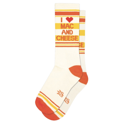 White socks with orange and yellow stripes and text "I Love Mac and Cheese". Anyone who enjoys a comforting bowl of mac & cheese will appreciate these socks. Whether you prefer to craft homemade recipes from scratch or are content with the convenience of store-bought boxes, there is no denying the warmth of these cheesy delights. Keep your feet cozy with a cotton/nylon/spandex blend and show your love for mac & cheese with a made-in-the-USA unisex design that fits most.