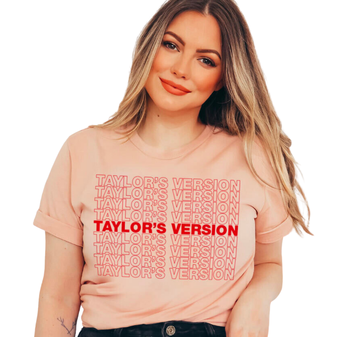 Pink shirt with red outline text "Taylor's Version". Taylor's unisex crew neck t-shirt is crafted with lightweight cotton for enduring comfort. Printed with water-based inks, it won't fade or crack. Additionally, these inks are non-toxic, so you can show your style confidently. Proudly made in the USA.