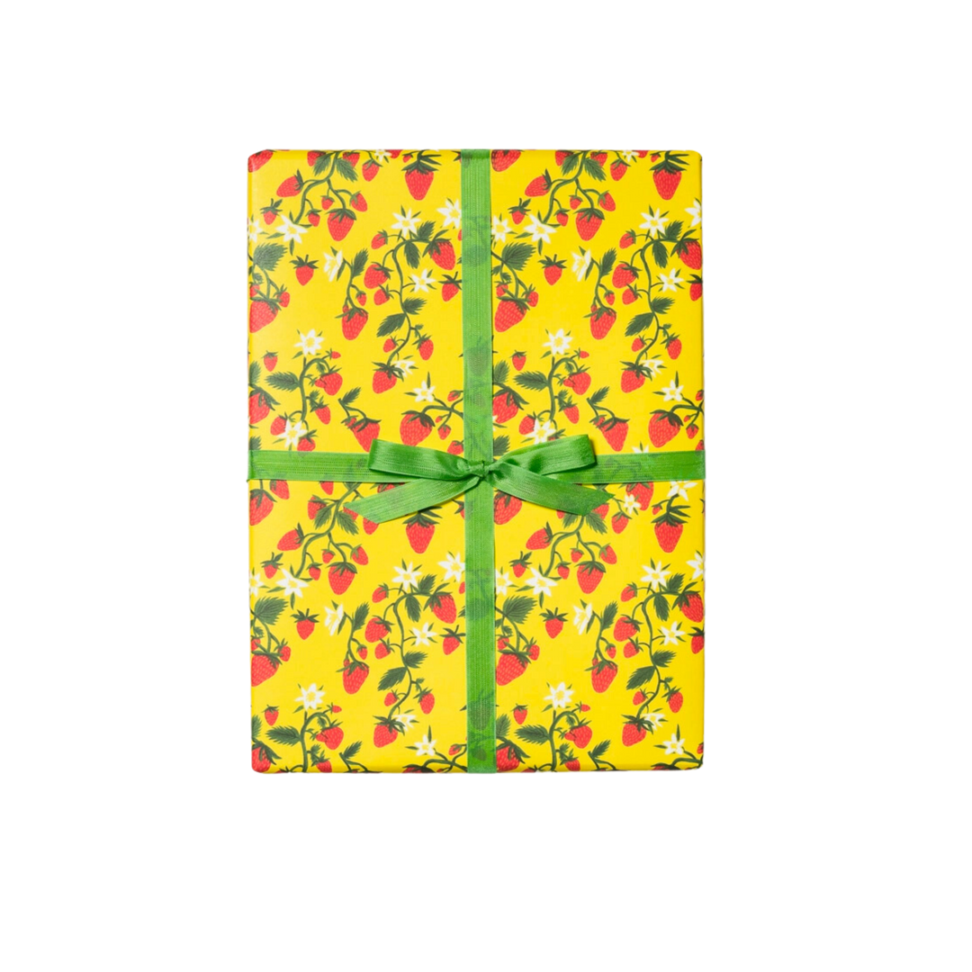 Illustrated strawberries on green stems with white flowers, on a yellow background. This package contains three 19 x 27 inch sheets of flat paper wrapping, rolled and tightly secured. Featuring artwork by Krista Perry, it is crafted in the United States of America.