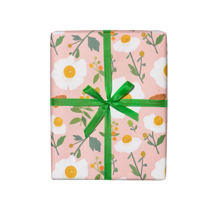 White flowers with green stems on a pink background. Sheet - Single (1) 19 x 27 inch sheet   Roll - Three (3) 19 x 27 inch sheets of flat wrap, rolled and sealed together.   Illustrated by Kate Pugsley. Printed in USA, on recycled paper.