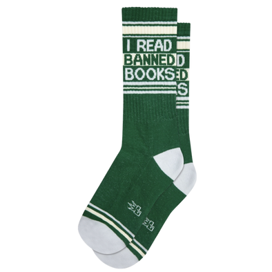 Green socks with white stripes and text "I Read Banned Books". Take a break and slip into these cushioned socks to discover the books the Man doesn't want you to read. Constructed with 61% Cotton, 36% Nylon, and 3% Spandex, these socks are proudly made in the USA.