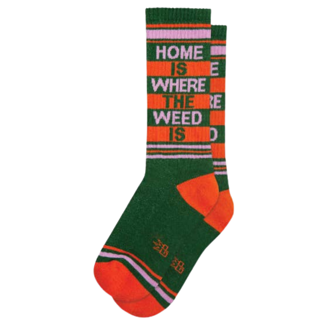 Green socks with pink and orange stripes and text reading "Home Is Where The Weed Is". No matter how you choose to partake, Home Is Where The Weed Is ribbed gym socks will provide a comfortable cushion for your feet. With 65% cotton, 32% nylon, and 3% spandex, they are made in the USA with unisex sizing for a comfortable fit. Get your chill on without worrying about your feet.