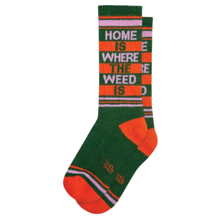 Green socks with pink and orange stripes and text reading "Home Is Where The Weed Is". No matter how you choose to partake, Home Is Where The Weed Is ribbed gym socks will provide a comfortable cushion for your feet. With 65% cotton, 32% nylon, and 3% spandex, they are made in the USA with unisex sizing for a comfortable fit. Get your chill on without worrying about your feet.
